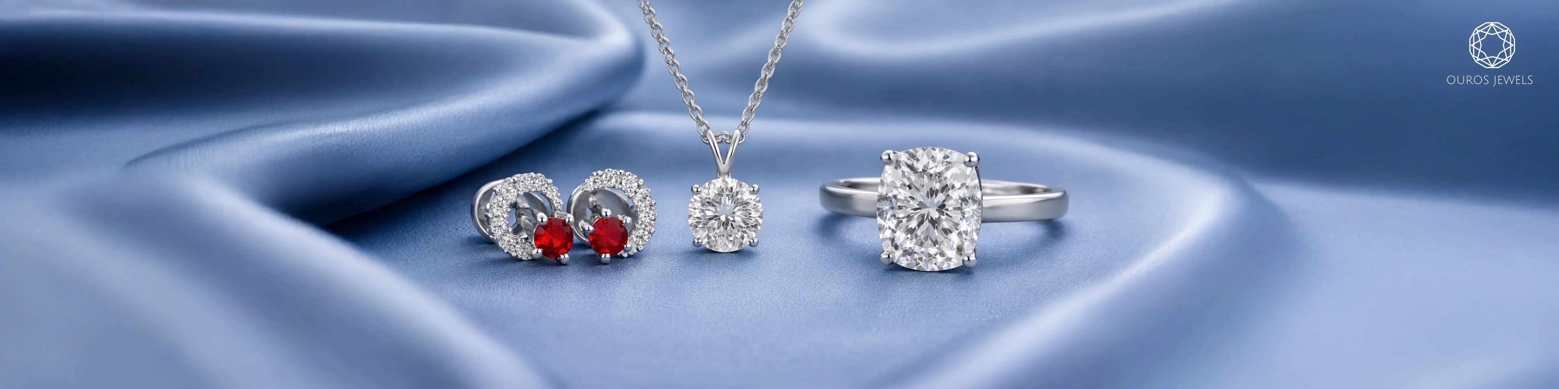 Ouros Jewels lab grown diamond jewelry set featuring ruby halo stud earrings, round diamond solitaire pendant necklace, and cushion cut diamond solitaire engagement ring