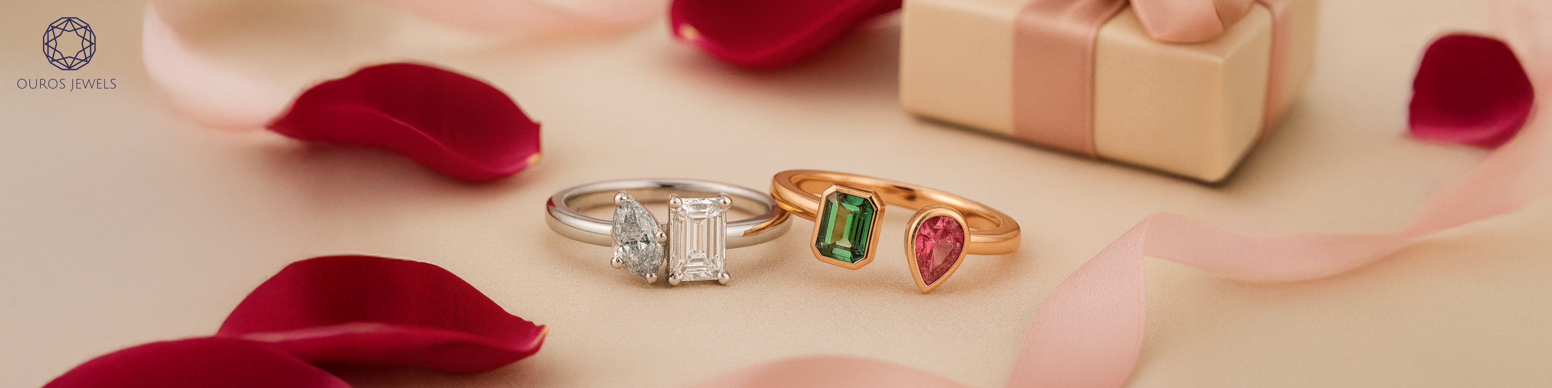 Elegant photo of unique toi et moi engagement rings with rose petals and a gift box. Featuring a blue marquise and emerald cut lab grown diamond two stone ring with Ruby Pear and Emerald Gemstone Toi Moi ring.