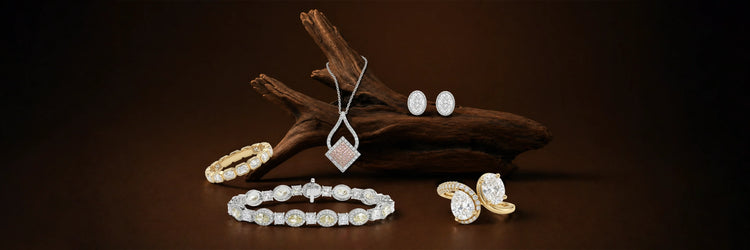 Lab-grown diamond jewelry collection in white and yellow gold — oval eternity band, kite pendant necklace, oval stud earrings, alternating oval and princess cut tennis bracelet, and pear cut bypass ring on dark driftwood display