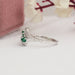 emerald gemstone and round diamond bypass ring 