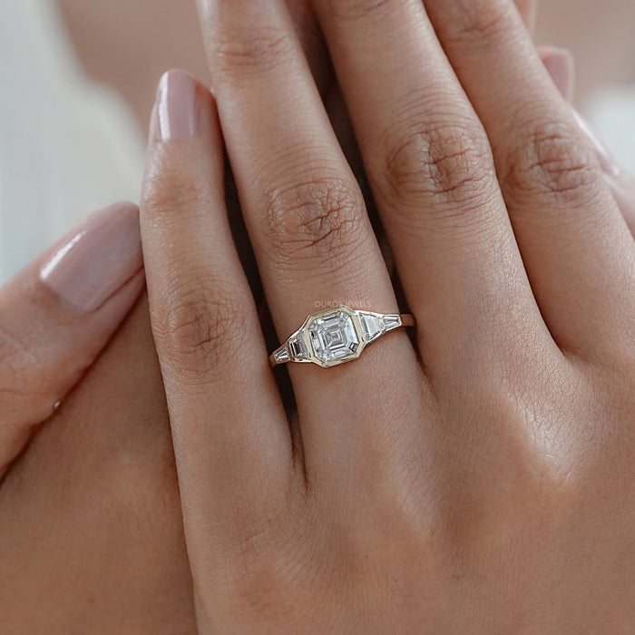 asscher and trapezoid cut lab diamond bezel five stone wedding ring on model's finger