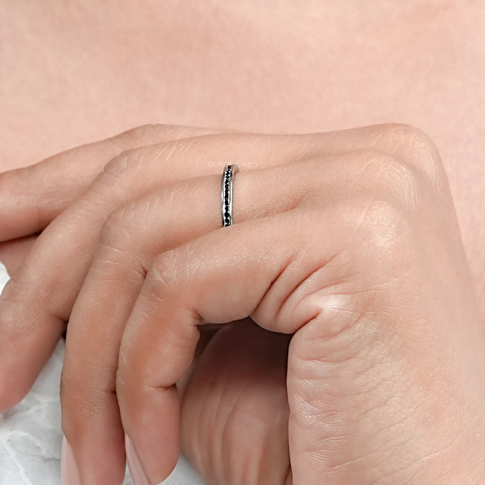 black round diamond channel-set half eternity band engagement ring on model's finger