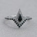 front view of black kite-cut lab diamond curved halo wedding ring on grey fabric