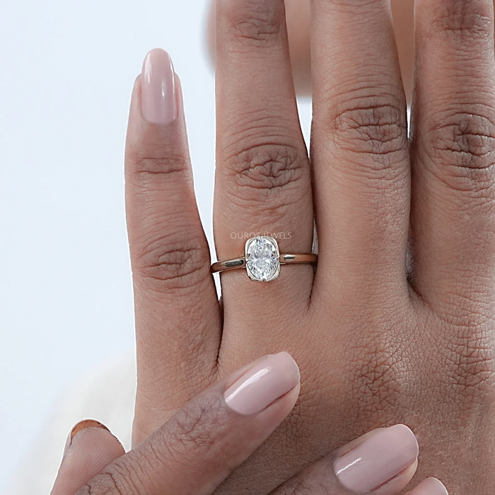 oval cut diamond solitaire button back engagement ring on model's hand