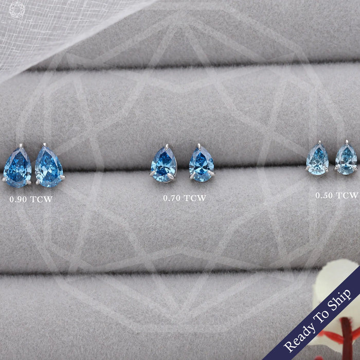 front view of blue pear cut lab grown diamond stud earrings white gold on box