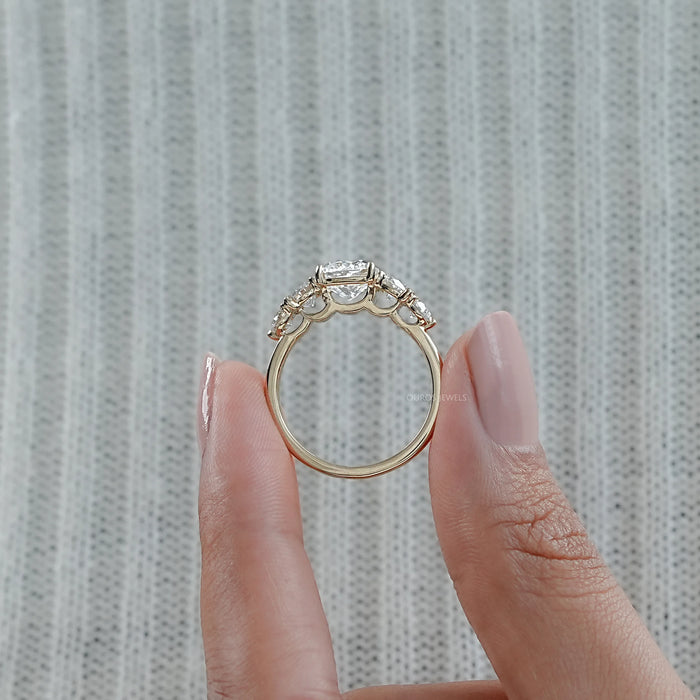 close view of cushion cut diamond five stone engagement ring in yellow gold band