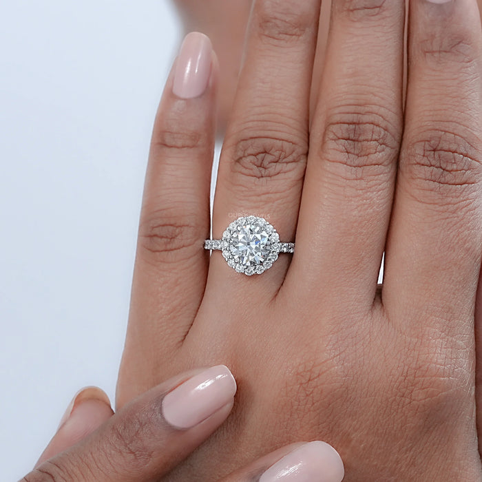 front view of round cut lab diamond halo engagement ring in finger