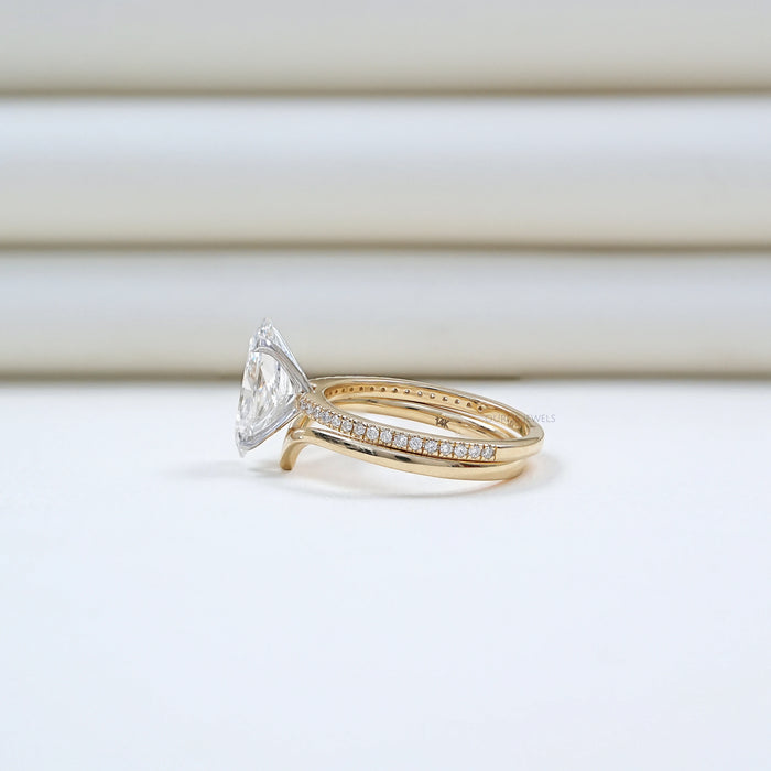 side view of dutch marquise-cut diamond curved engagement ring with 2 yellow bands