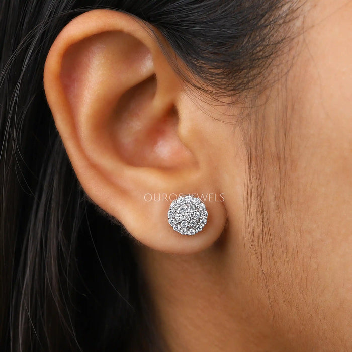 Cluster Round Cut Diamond Stud Earrings worn on a woman's ear, showcasing the sparkling diamond clusters against her skin.