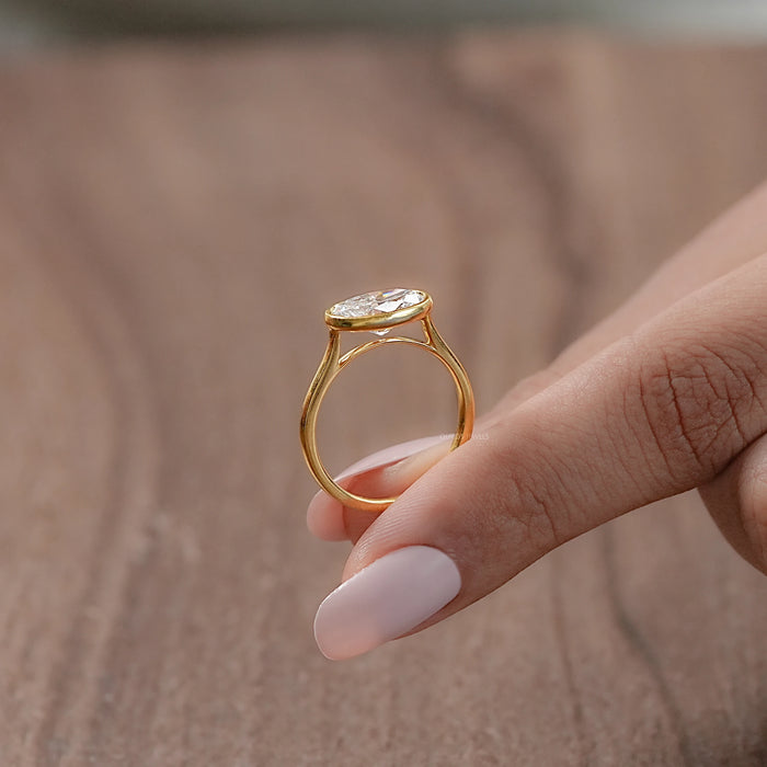 bezel set east west oval cut diamond engagement ring with side angle view
