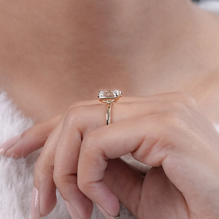 emerald and champagne oval-cut diamond toi et moi engagement ring on model's finger