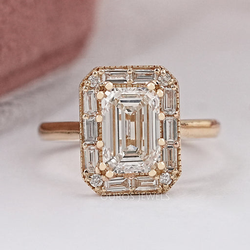 front view of emerald diamond baguette halo engagement ring in yellow gold band