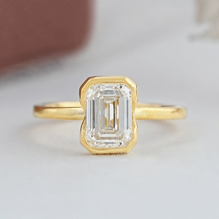 top view of emerald cut lab diamond bezel set solitaire engagement ring