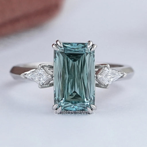front view of green scissors cut diamond double prong three stone engagement ring