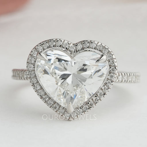 heart cut lab diamond halo engagement ring's front angle view on grey fabric