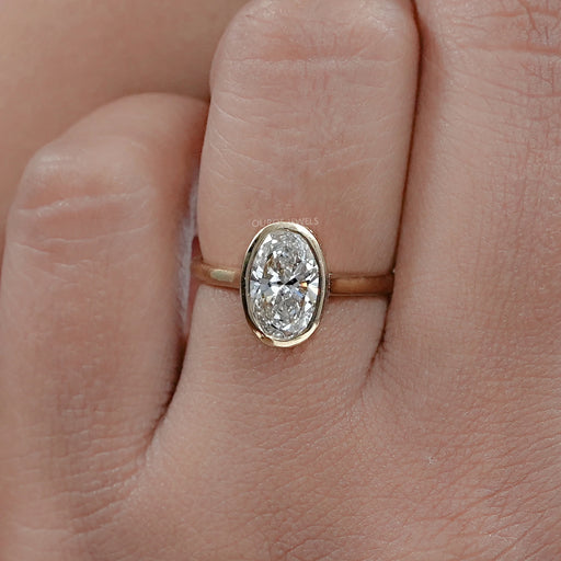 front view of oval diamond hidden halo bezel engagement ring in finger