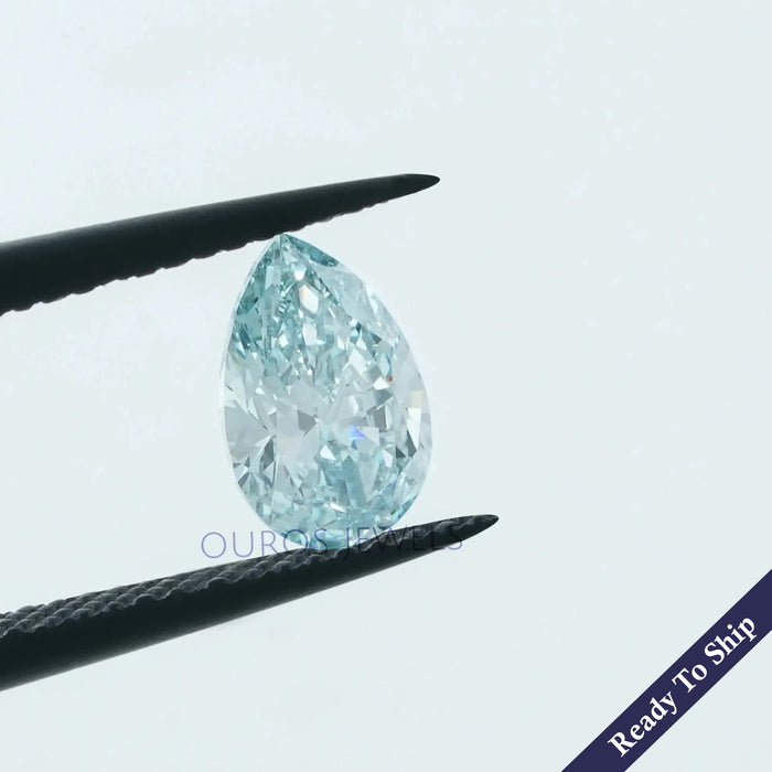 1.07 carat light blue diamond pear shape lab grown loose stone held with tweezer