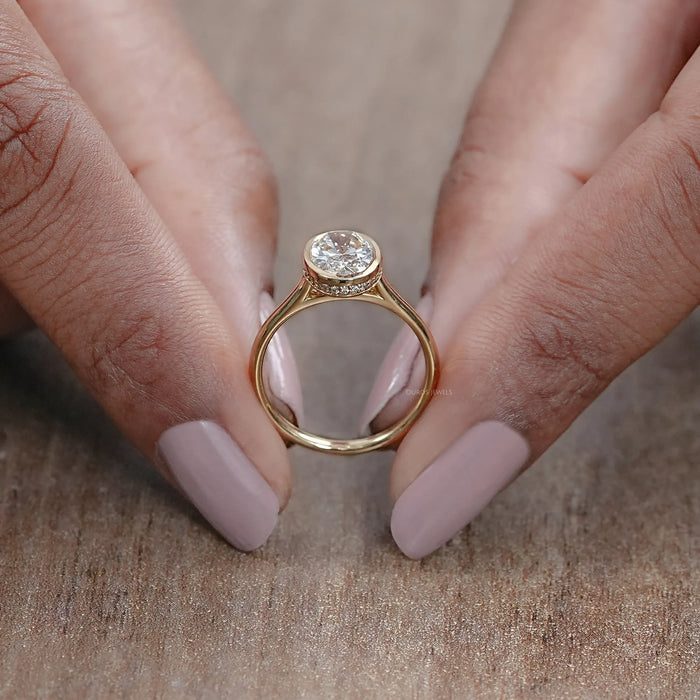 close up view of oval cut lab diamond hidden halo bezel set engagement ring