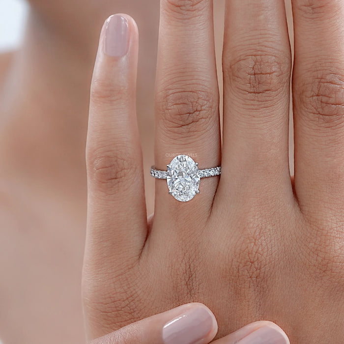 oval cut lab-grown diamond hidden halo solitaire engagement ring on model's finger