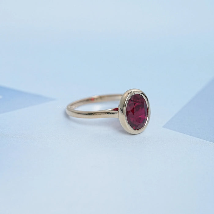 side view of oval cut ruby lab gemstone bezel set solitaire ring