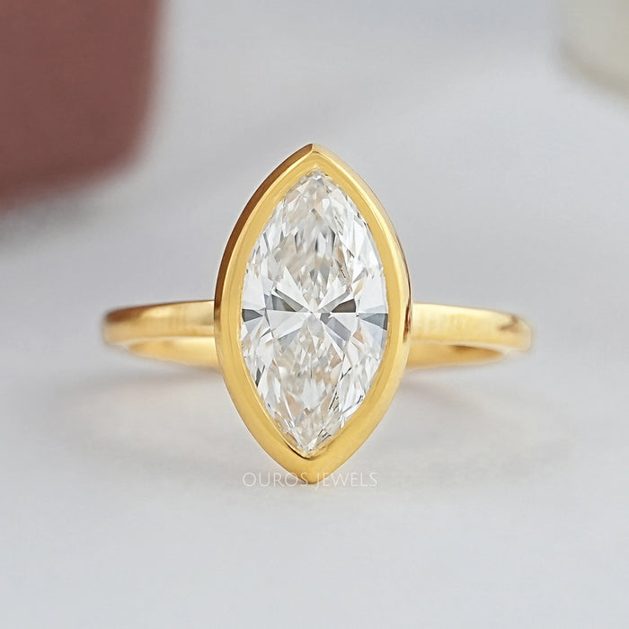 marquise cut diamond bezel set engagement ring in yellow gold band top view