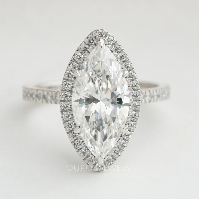 front view of marquise cut lab diamond halo engagement ring on grey fabric