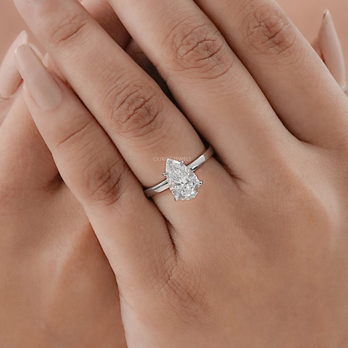 pear cut lab diamond solitaire engagement ring on model's hand