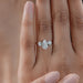 three stone pear cut lab diamond hidden halo engagement ring in finger