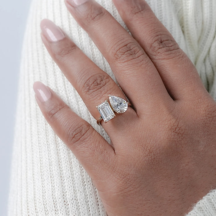 pear and emerald cut diamond two-stone toi et moi engagement ring on model's finger