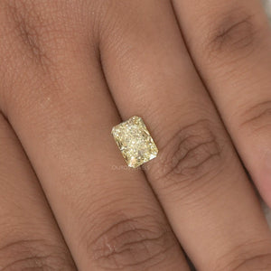 2.15 Carat Fancy Intense Yellow Radiant Cut Lab Diamond placed on a finger, highlighting its size and sparkle against the skin.