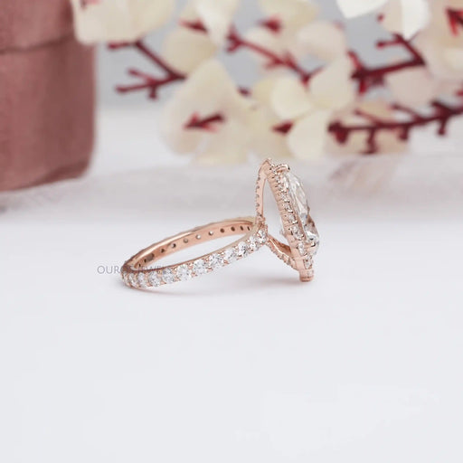 side view of pear cut lab diamond halo engagement ring in rose gold band
