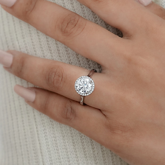 round brilliant cut lab diamond halo engagement ring on model's finger