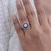 old european round cut diamond sapphire halo engagement ring in finger