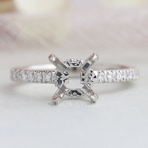 front view of round-shaped hidden halo semi-mount engagement ring on grey fabric