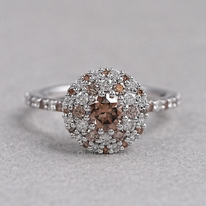 top view of brown round shape diamond cluster halo engagement ring on grey fabric