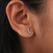 round lab diamond curved bar stud earrings white gold on model's ear