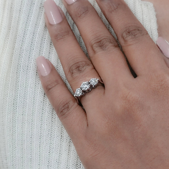 old european round cut lab diamond three stone engagement ring in finger