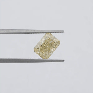 2.15 Carat Fancy Intense Yellow Radiant Cut Lab Diamond hold by tweezers against a plain grey background.