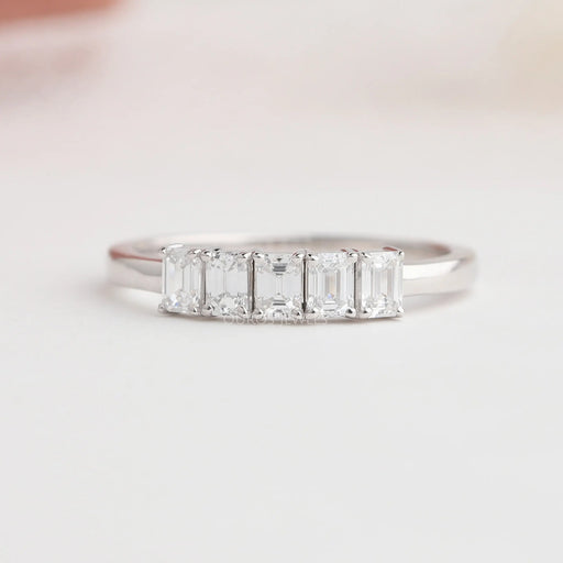 front view of emerald cut lab diamond five stone wedding band on grey fabric