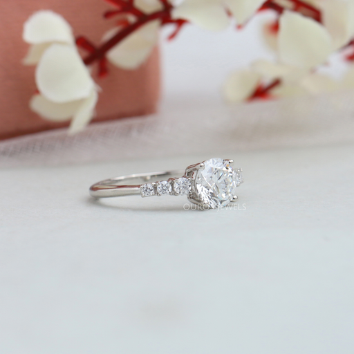 side view of 7 stone round-cut diamond solitaire accent engagement ring on fabric